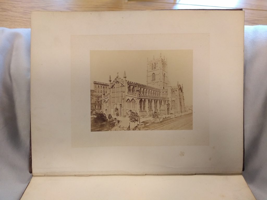 A book on a book cushion, open to a photograph of St Mary's Church, Nottingham